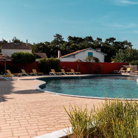 Outdoor swimming pool with deckchairs at a campsite in Charente-Maritime