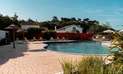 Piscina exterior con tumbonas en un camping de Charente-Maritime