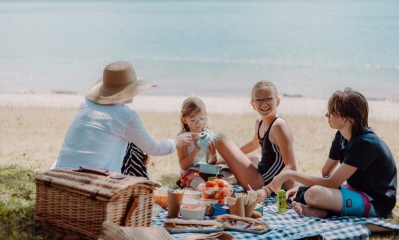 Famille pique-niquant sur la plage d’un lac de montagne en été