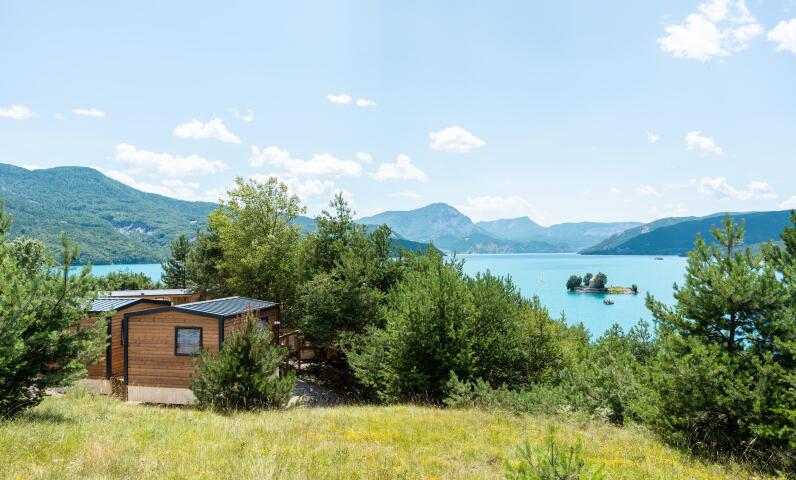 Uitzicht op een meer, omringd door bergen, in de zomer
